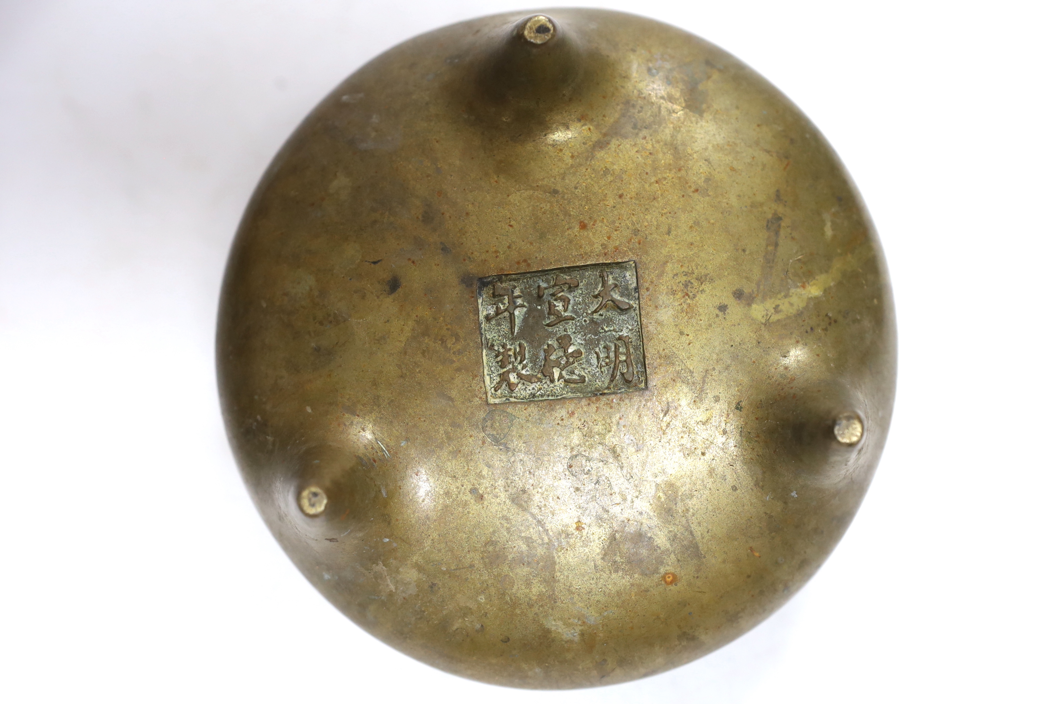 A Chinese bronze censer with twin handles and tripod feet, 18cm wide